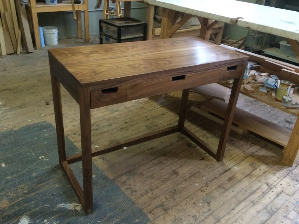 Hand-planed desk made from solid eastern black walnut with hard maple drawers and a book-matched top.